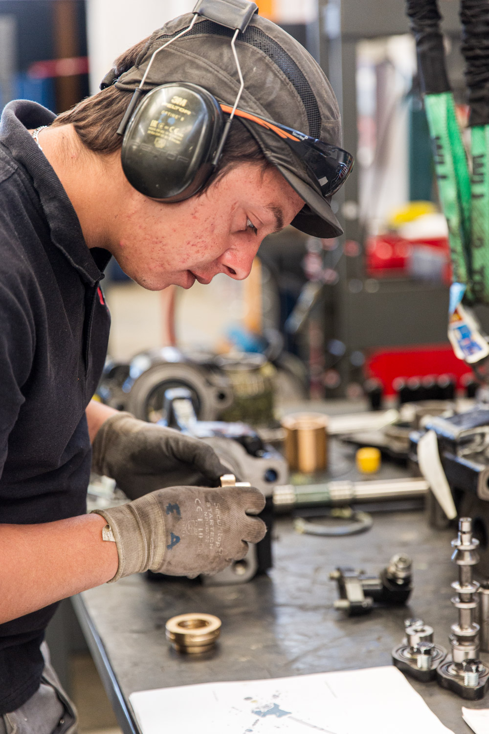 Le mécanicien assemble les pièces sur son établi. Photographie de reportage industriel